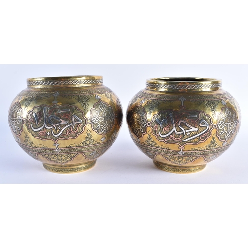 70 - A PAIR OF LATE 19TH CENTURY ISLAMIC MIDDLE EASTERN SILVER INLAID VASES decorated with scripture and ... 