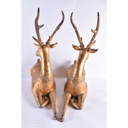 799 - A LARGE PAIR OF 18TH/19TH CENTURY INDIAN LACQUERED BRONZE DEER decorated with motifs. 54 cm x 50 cm.