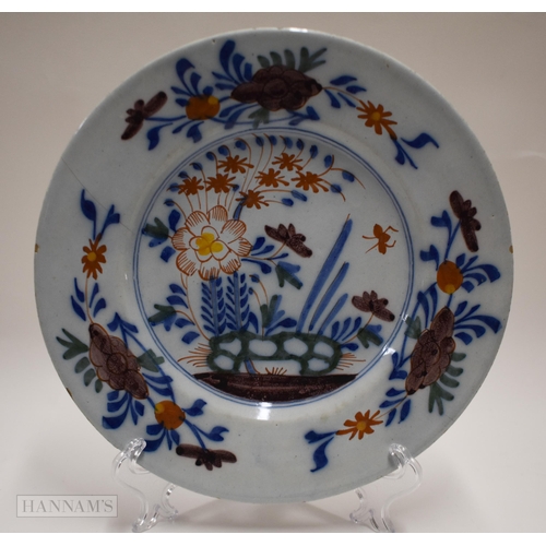 866 - Mid 18th century Lambeth polychrome plate painted with a large flower, smaller flowers, leaves and h... 