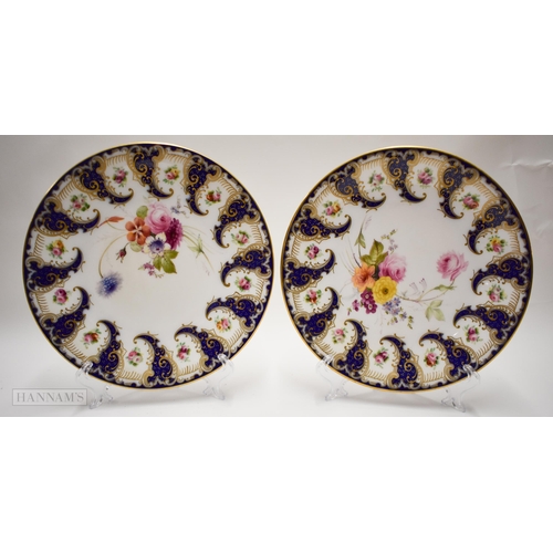 872 - Royal Worcester pair of plates painted with flowers between swirling blue cornucopia, the centre pai... 