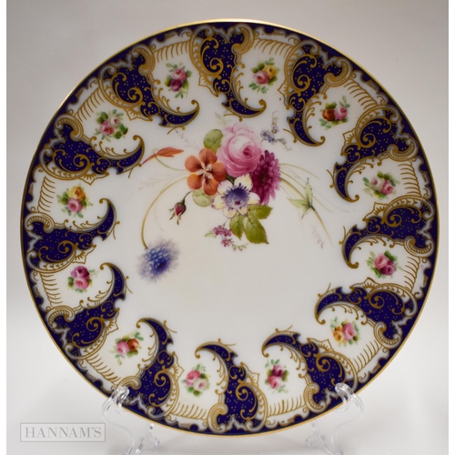 872 - Royal Worcester pair of plates painted with flowers between swirling blue cornucopia, the centre pai... 