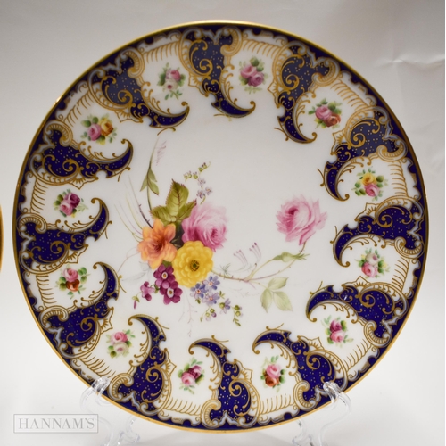 872 - Royal Worcester pair of plates painted with flowers between swirling blue cornucopia, the centre pai... 