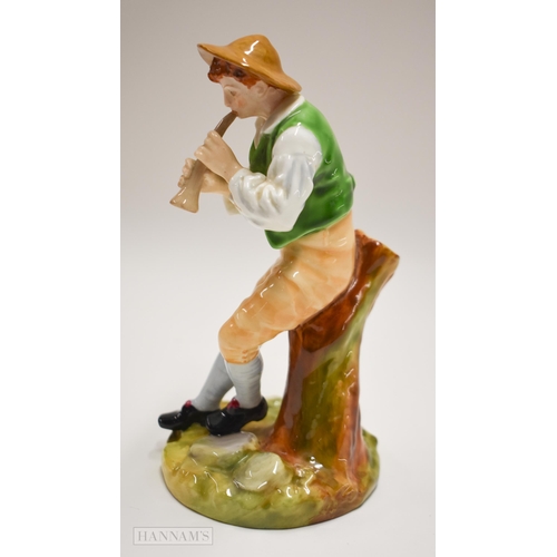 875 - Royal Worcester figure of a boy playing a pipe seated on a tree stump, painted in bright colours, ti... 