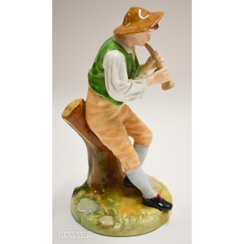 875 - Royal Worcester figure of a boy playing a pipe seated on a tree stump, painted in bright colours, ti... 