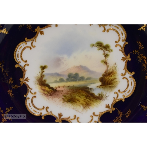 876 - Coalport plate with gilding on a cobalt blue ground, painted by P. Simpson, signed, with a scene nr.... 