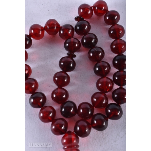 1954 - A CHERRY AMBER TYPE NECKLACE. 22 grams. 60 cm long overall, largest bead 5 cm long.