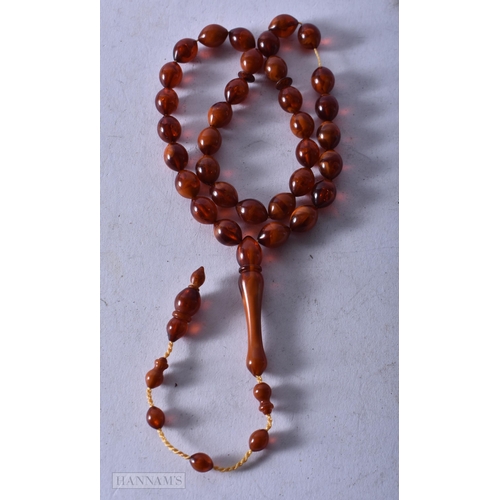 1955 - AN AMBER TYPE NECKLACE. 21 grams. 72 cm long, largest bead 4.5 cm long.