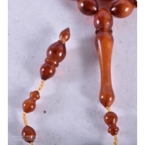 1955 - AN AMBER TYPE NECKLACE. 21 grams. 72 cm long, largest bead 4.5 cm long.