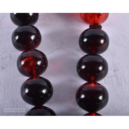 1956 - A CHERRY AMBER TYPE BRACELET. 29 grams. Bracelet 8 cm diameter, ;largest bead 3.5 cm long.