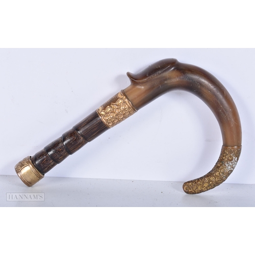 3641 - A Rhino horn handled cane handle with gilt metal collars and decoration 17cm.