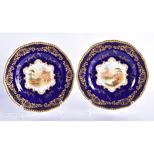 169 - A FINE PAIR OF COALPORT CABINET PLATES by Simpson, painted with landscapes. 24 cm wide.