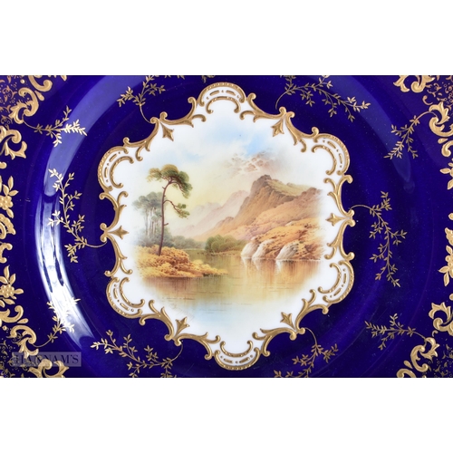 169 - A FINE PAIR OF COALPORT CABINET PLATES by Simpson, painted with landscapes. 24 cm wide.