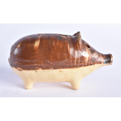 17 - A CHARMING ANTIQUE TREACLE GLAZED SLIP DECORATED POTTERY PIG MONEY BOX. 12 cm wide.