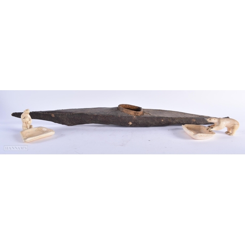 298 - AN ANTIQUE TRIBAL INUIT RAY SKIN CANOE together with two Inuit bone polar bear dishes. Largest 57 cm... 