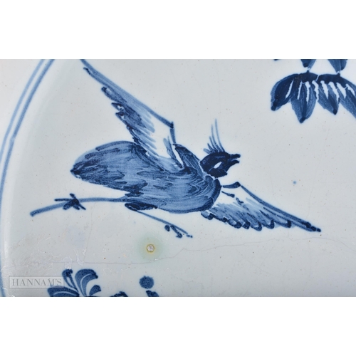 317 - A LARGE 18TH CENTURY DELFT BLUE AND WHITE TIN GLAZED DISH painted with birds and a fenced garden. 30... 