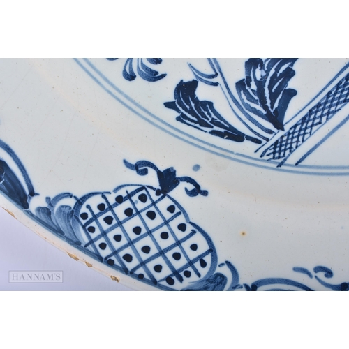 317 - A LARGE 18TH CENTURY DELFT BLUE AND WHITE TIN GLAZED DISH painted with birds and a fenced garden. 30... 