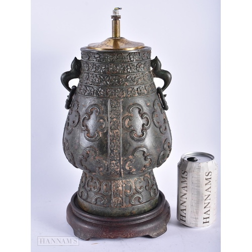 321 - A 19TH CENTURY INDIAN TWIN HANDLED BRONZE COUNTRY HOUSE LAMP decorated with motifs. 34 cm x 14cm.