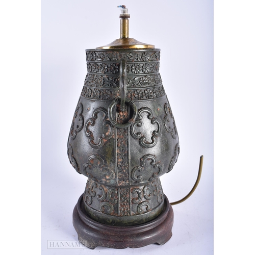 321 - A 19TH CENTURY INDIAN TWIN HANDLED BRONZE COUNTRY HOUSE LAMP decorated with motifs. 34 cm x 14cm.