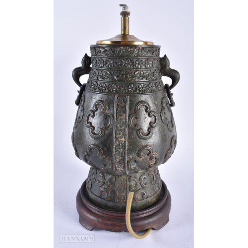 321 - A 19TH CENTURY INDIAN TWIN HANDLED BRONZE COUNTRY HOUSE LAMP decorated with motifs. 34 cm x 14cm.