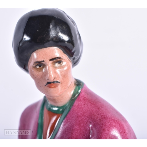 335 - A VERY RARE EARLY 20TH CENTURY RUSSIAN SOVIET PORCELAIN FIGURE OF A MALE modelled wearing a pink rob... 