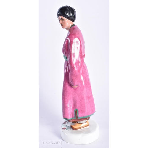 335 - A VERY RARE EARLY 20TH CENTURY RUSSIAN SOVIET PORCELAIN FIGURE OF A MALE modelled wearing a pink rob... 