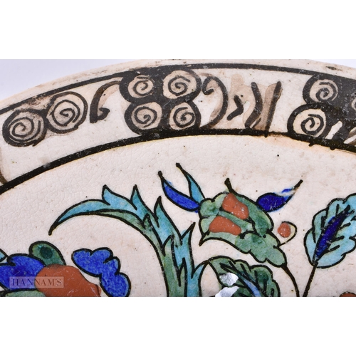 421 - AN ISLAMIC TURKISH FAIENCE IZNIK DISH. 24 cm diameter.