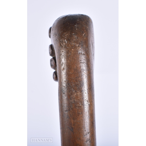 447 - AN ANTIQUE FOLK ART CARVED WOOD FIST CLENCHING SWAGGER STICK. 50 cm long.