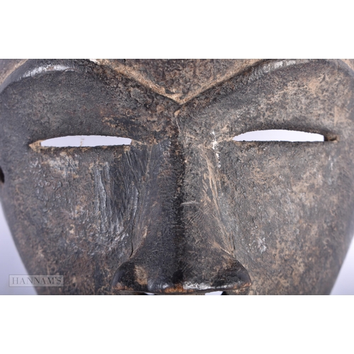 464 - AN AFRICAN CARVED WOOD TRIBAL DAN MASK. 18cm x 12 cm.