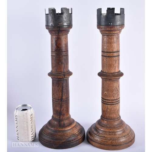 5 - A PAIR OF ENGLISH MULBERRY OAK TURRET FORM CANDLESTICKS. 42cm high.