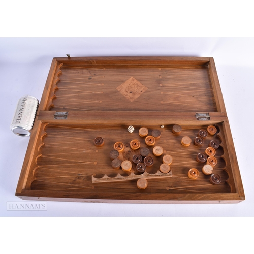 56 - A LARGE EARLY 20TH CENTURY MIXED WOOD FOLDING GAMING BOARD with counters. 54 cm x 46cm open.