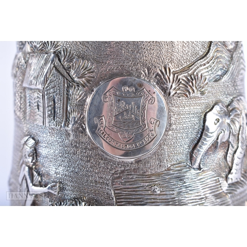 574 - AN INDIAN SILVER REPOUSSE MUG. 285 grams. 15cm high.