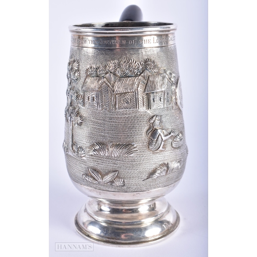 574 - AN INDIAN SILVER REPOUSSE MUG. 285 grams. 15cm high.