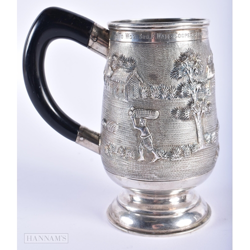 574 - AN INDIAN SILVER REPOUSSE MUG. 285 grams. 15cm high.