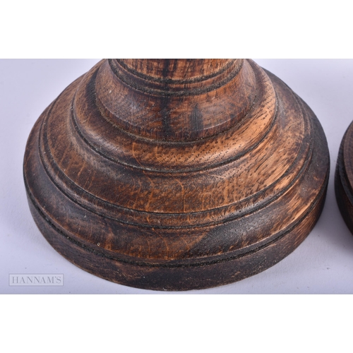 5 - A PAIR OF ENGLISH MULBERRY OAK TURRET FORM CANDLESTICKS. 42cm high.