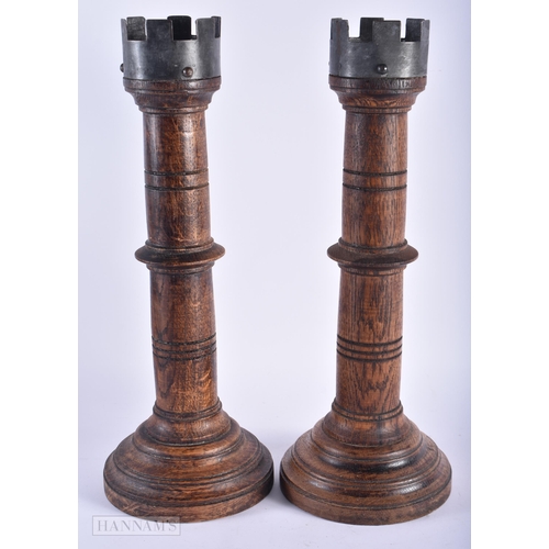 5 - A PAIR OF ENGLISH MULBERRY OAK TURRET FORM CANDLESTICKS. 42cm high.