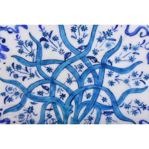 643 - A TURKISH OTTOMAN IZNIK POTTERY PLATE painted with a stylised tree. 33cm wide.