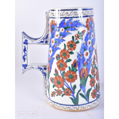 669 - A TURKISH ISLAMIC IZNIK FAIENCE POTTERY MUG. 20 cm high.