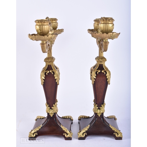 679 - A PAIR OF ART NOUVEAU FRENCH CARVED WOOD AND BRONZE CANDLESTICKS. 34 cm x 22cm.