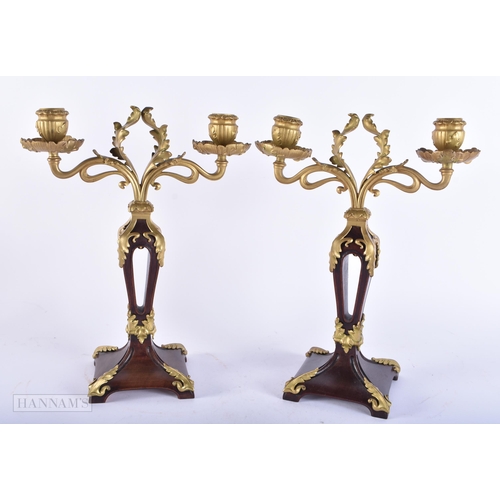 679 - A PAIR OF ART NOUVEAU FRENCH CARVED WOOD AND BRONZE CANDLESTICKS. 34 cm x 22cm.