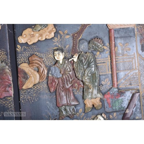 703 - A 19TH CENTURY CHINESE BLACK LACQUER SOAPSTONE SCREEN decorated with figures in various pursuits. 90... 