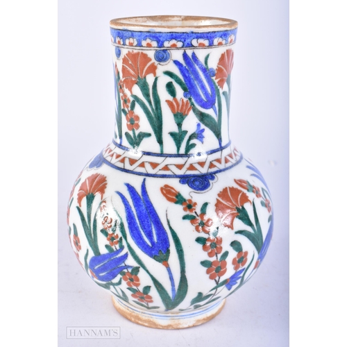 719 - A TURKISH IZNIK POTTERY FAIENCE JUG. 19 cm high.