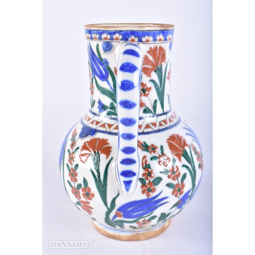 719 - A TURKISH IZNIK POTTERY FAIENCE JUG. 19 cm high.