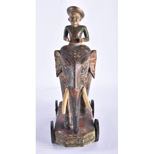 99 - AN ANTIQUE INDIAN PAINTED WOOD TOY modelled as an elephant with attendant. 27cm x 18cm.