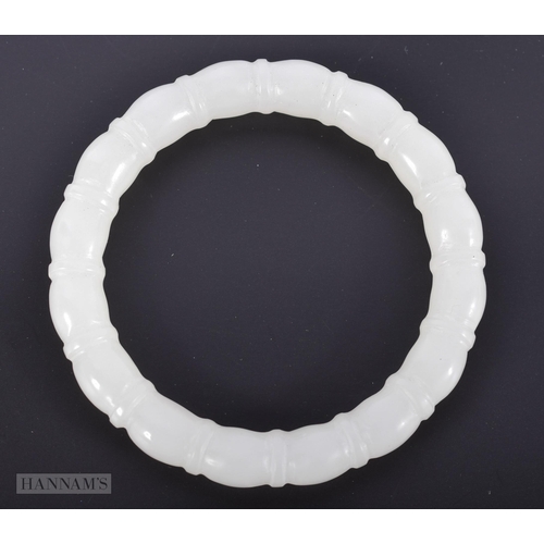 2653 - A CHINESE CARVED WHITE JADE RIBBED BANGLE. 48.1 grams. Internal diameter 6 cm.