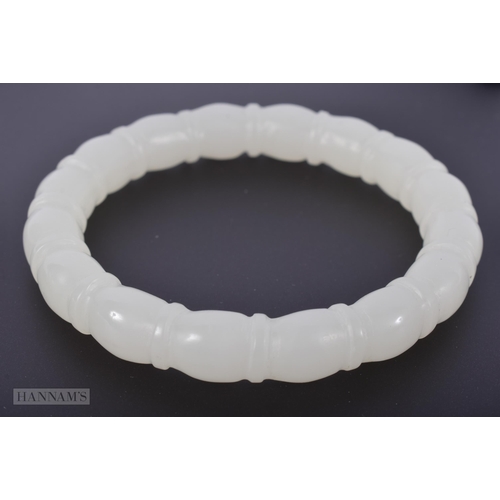 2653 - A CHINESE CARVED WHITE JADE RIBBED BANGLE. 48.1 grams. Internal diameter 6 cm.