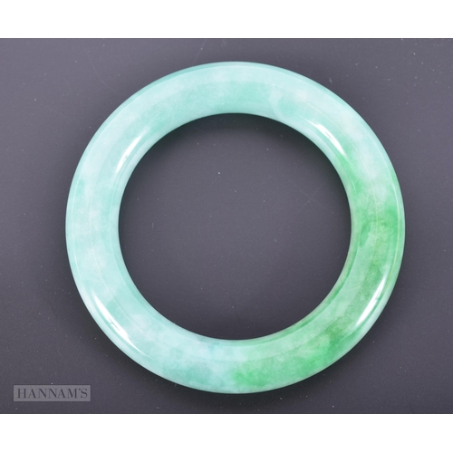 2656 - A CHINESE JADEITE BANGLE. 90.9 grams. 5.75 cm internal diameter.