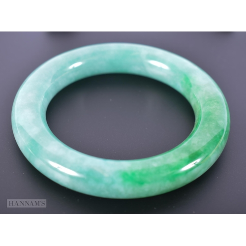 2656 - A CHINESE JADEITE BANGLE. 90.9 grams. 5.75 cm internal diameter.