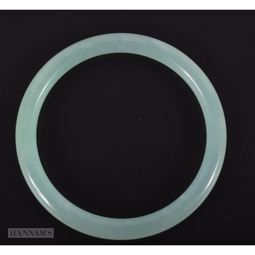 2664 - A CHINESE ICEY JADE CELADON BANGLE. 25.4 grams. Internal diameter 6 cm.