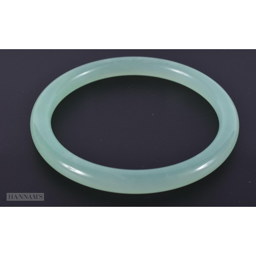 2664 - A CHINESE ICEY JADE CELADON BANGLE. 25.4 grams. Internal diameter 6 cm.