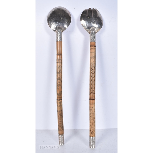 3012 - A pair of carved bamboo and engraved white metal  salad servers decorated with South East Asian char... 